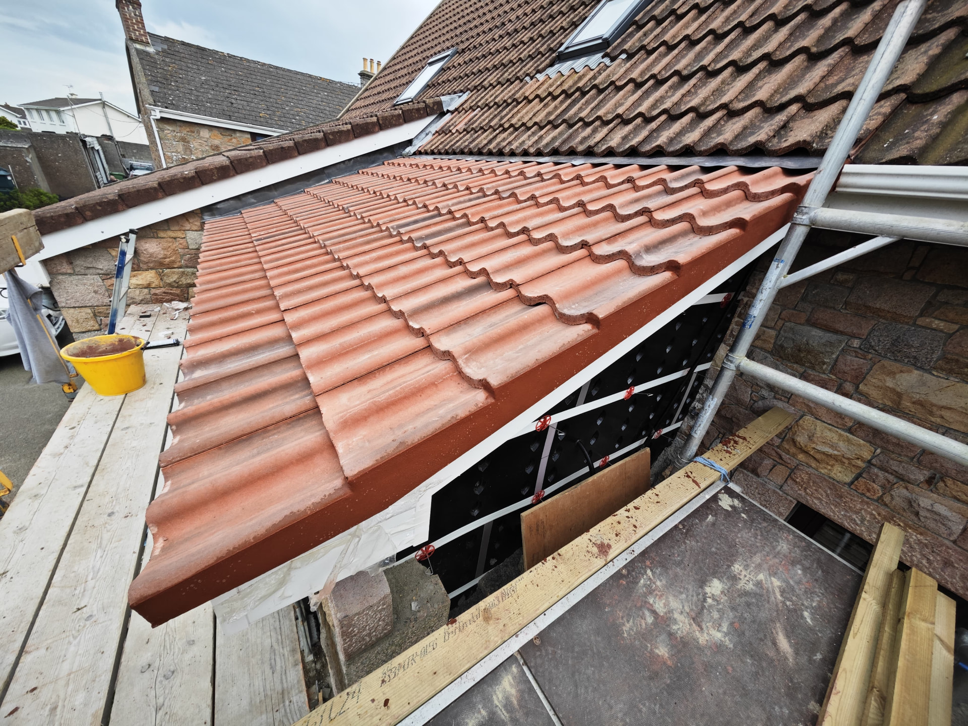 New tiled lean-to roof with lead flashings against a granite wall, Les Chaumiers