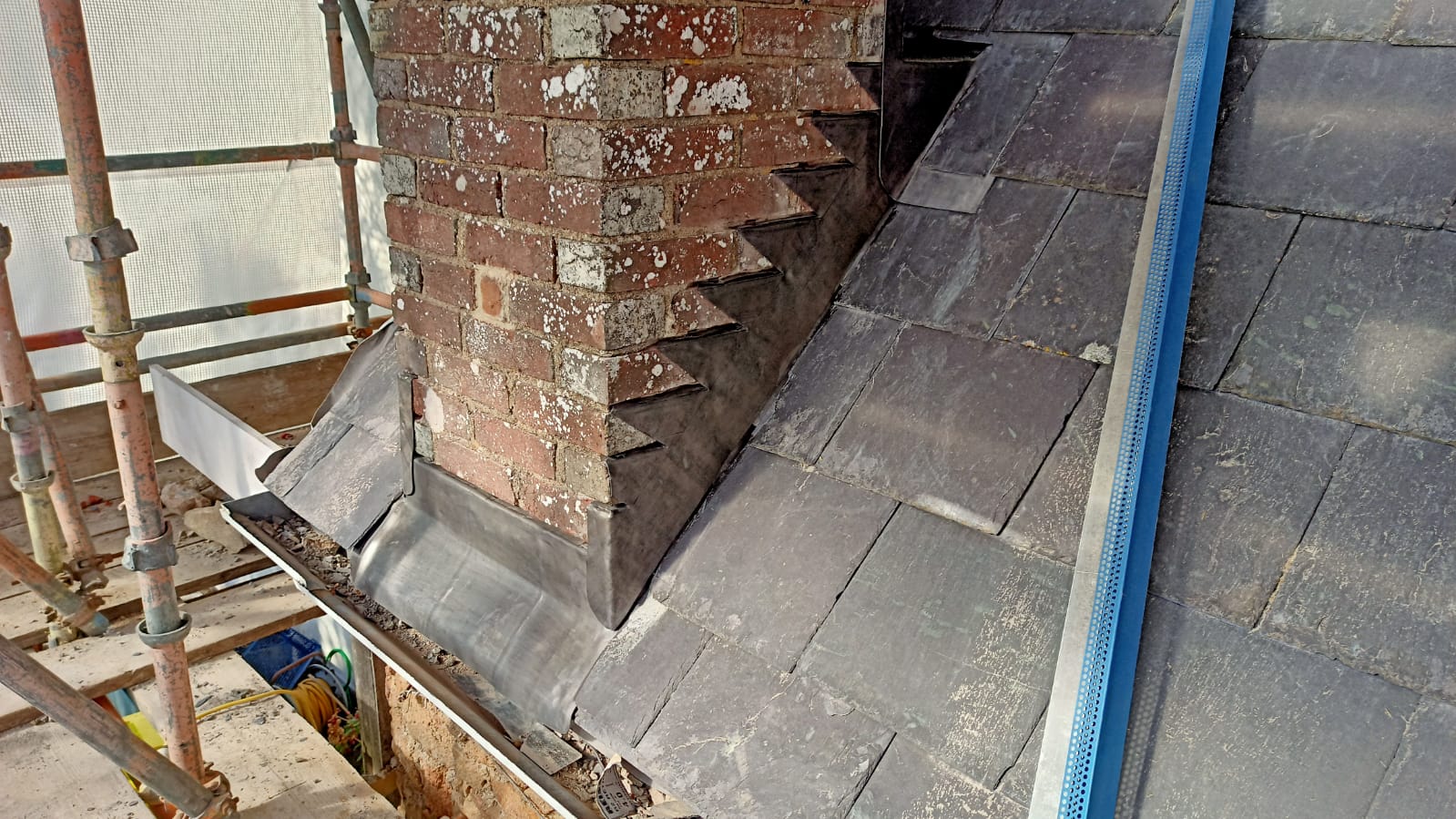 Lead step flashing and back gutter to a brick chimney, Le Hocq