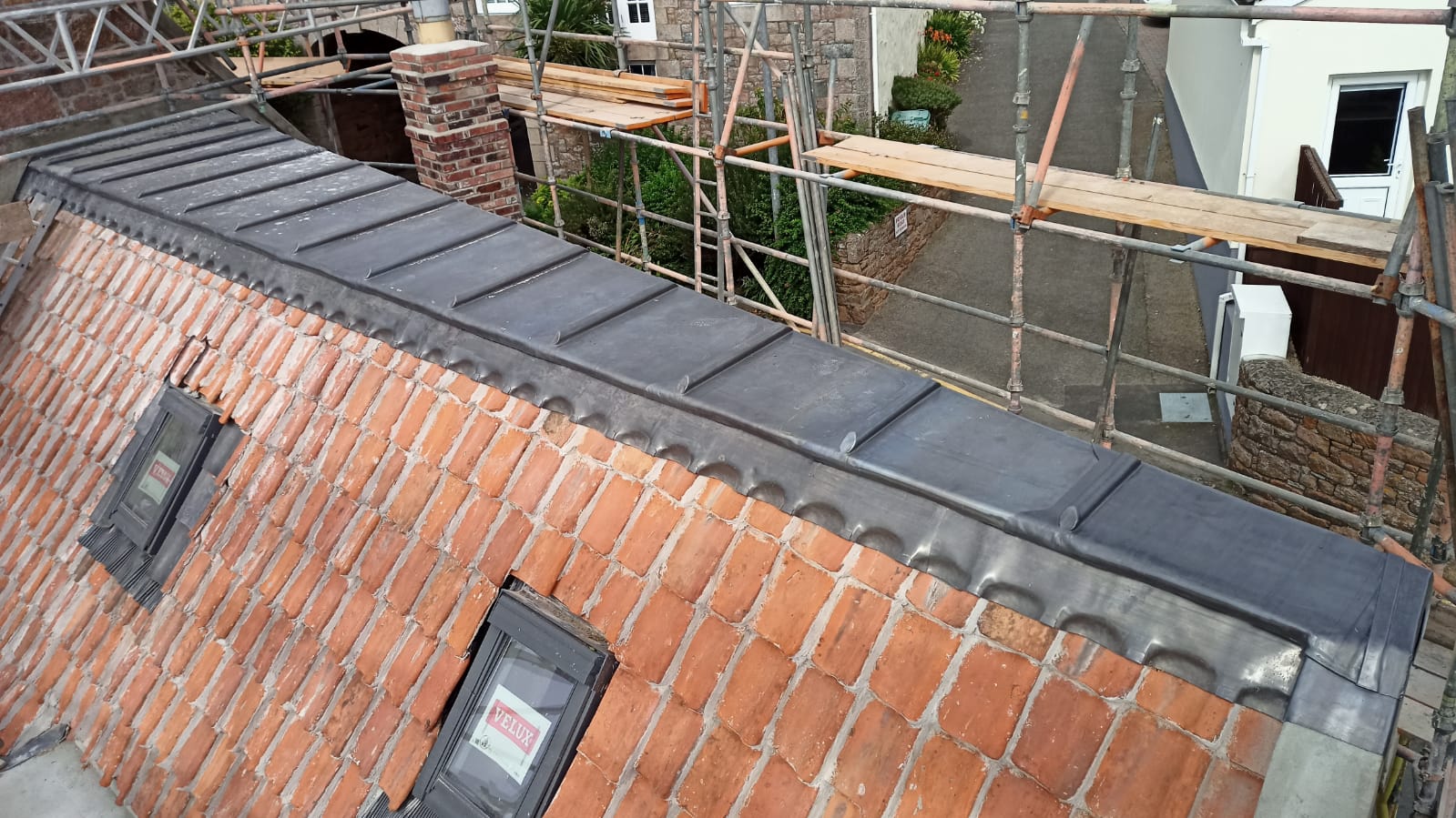 Lead-covered ridge across a clay pantile roof, Le Hocq