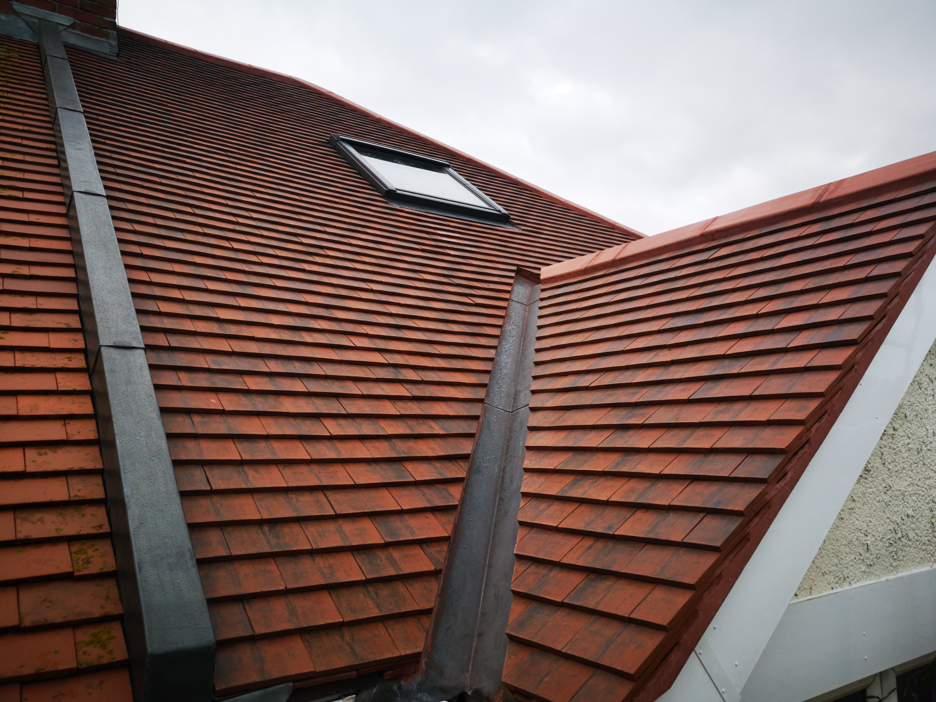 Red plain tile roof with velux window and lead valleys
