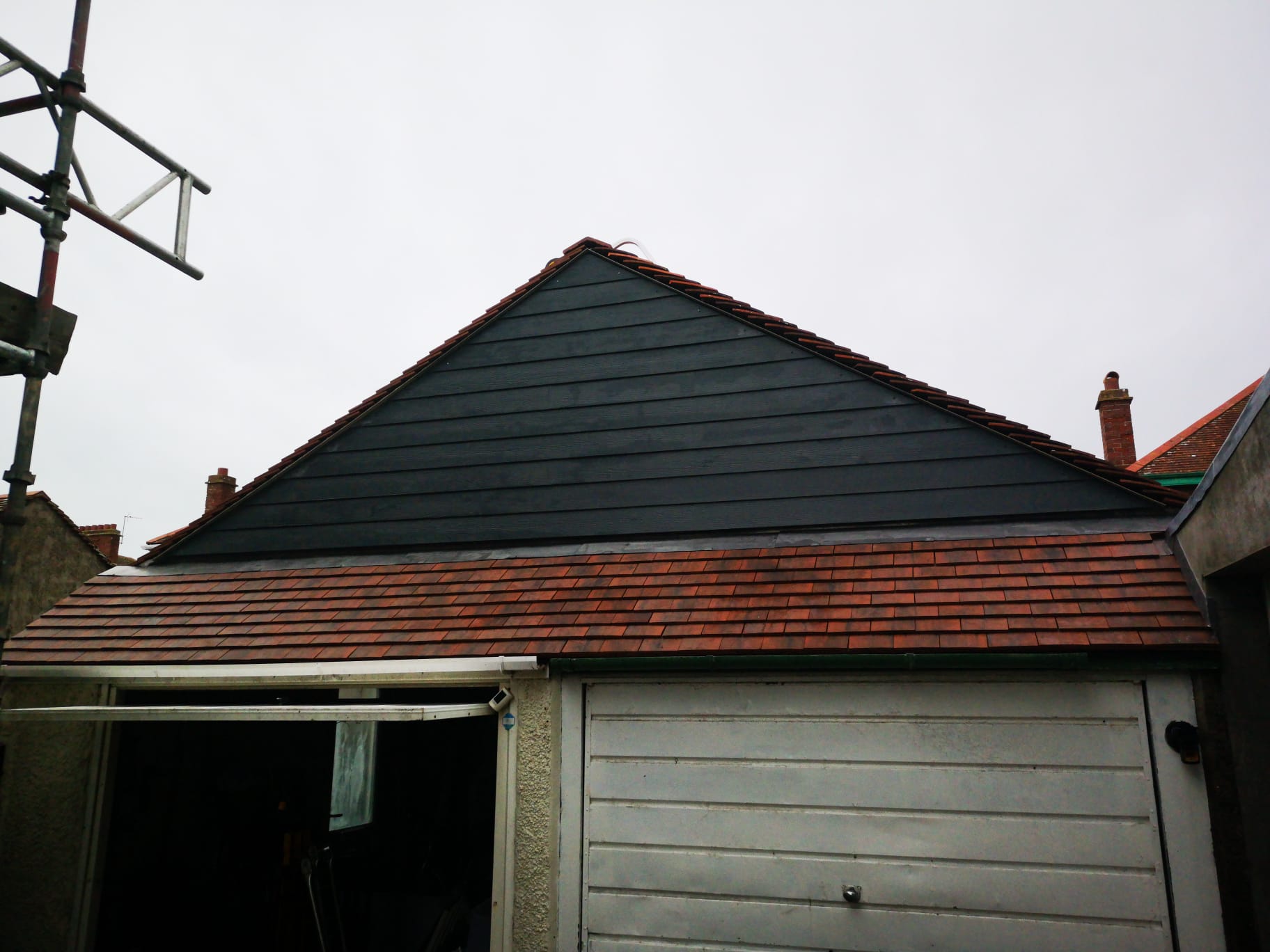 Plain tile garage roof with dark cladding gable