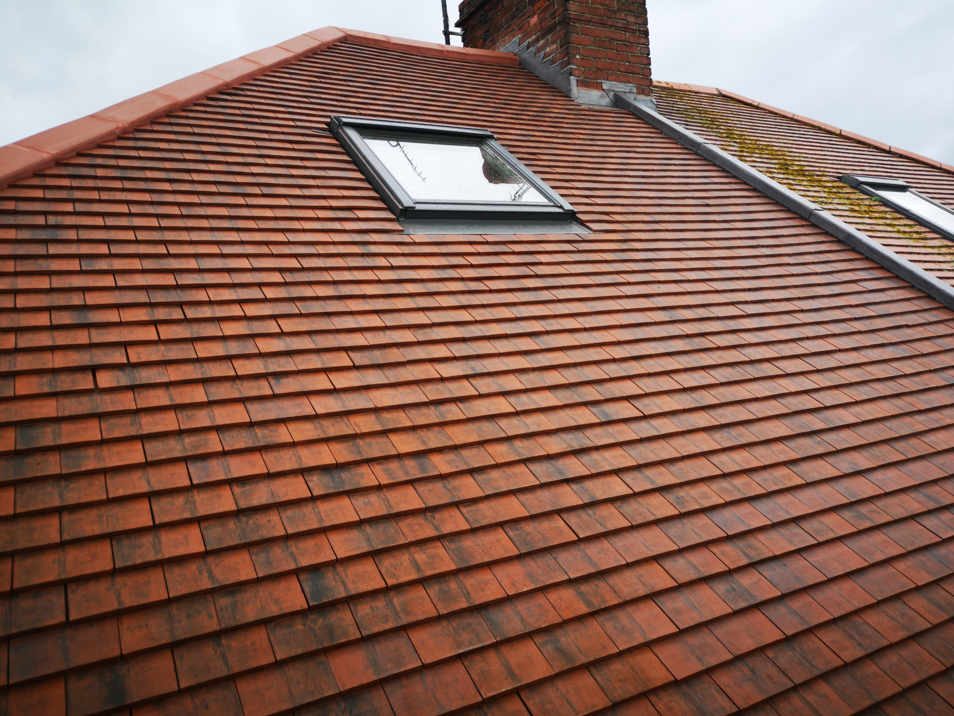 Wide red plain tile roof slope with velux windows