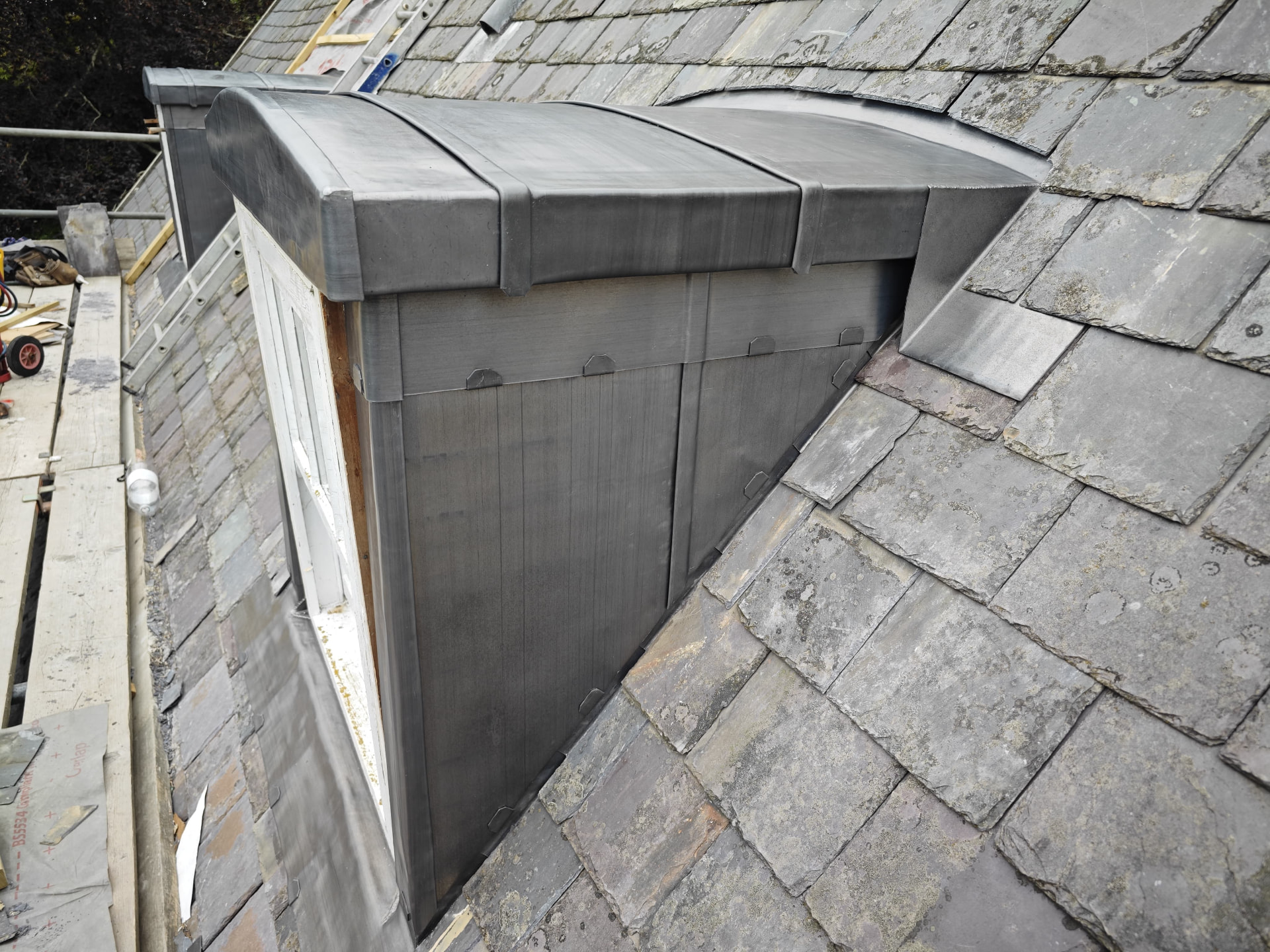 Curved lead dormer roof and lead cheeks on a slate roof, Franc Fief