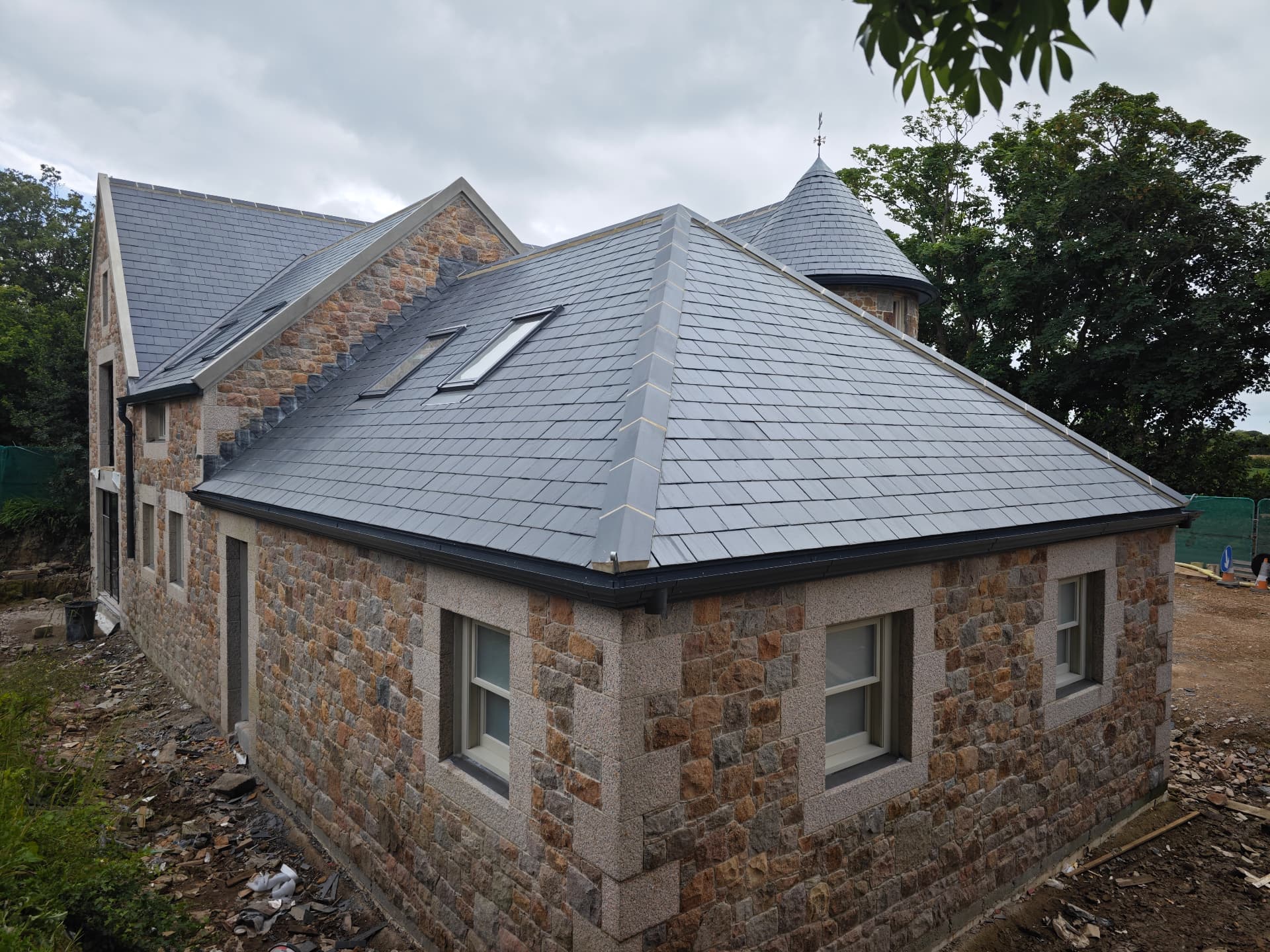 Hipped Spanish slate roof with velux windows on a granite house, La Grande Rue
