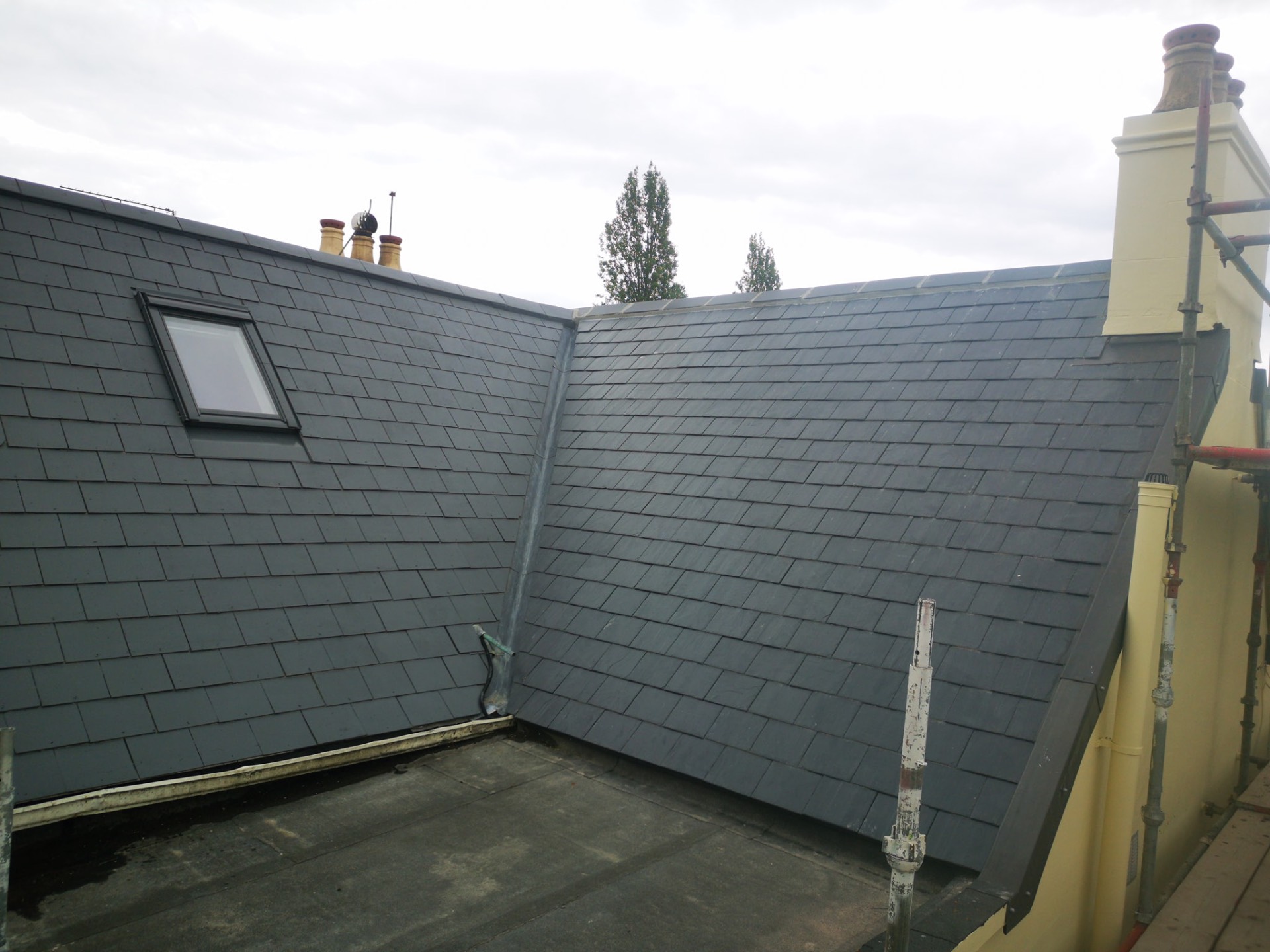 Newly laid grey slate roof with velux window