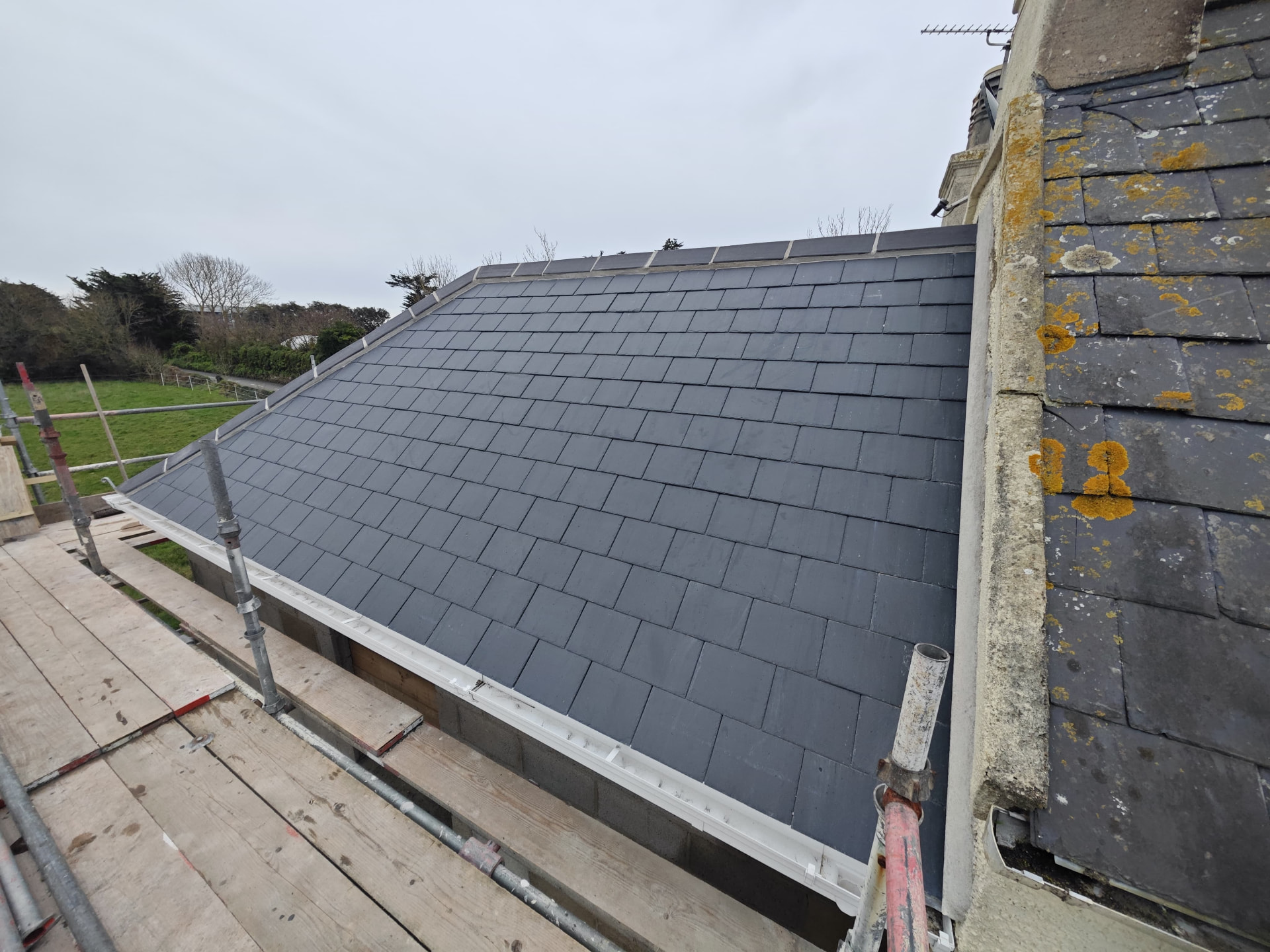 Slate roof slope on a new extension with new guttering, Corbiere