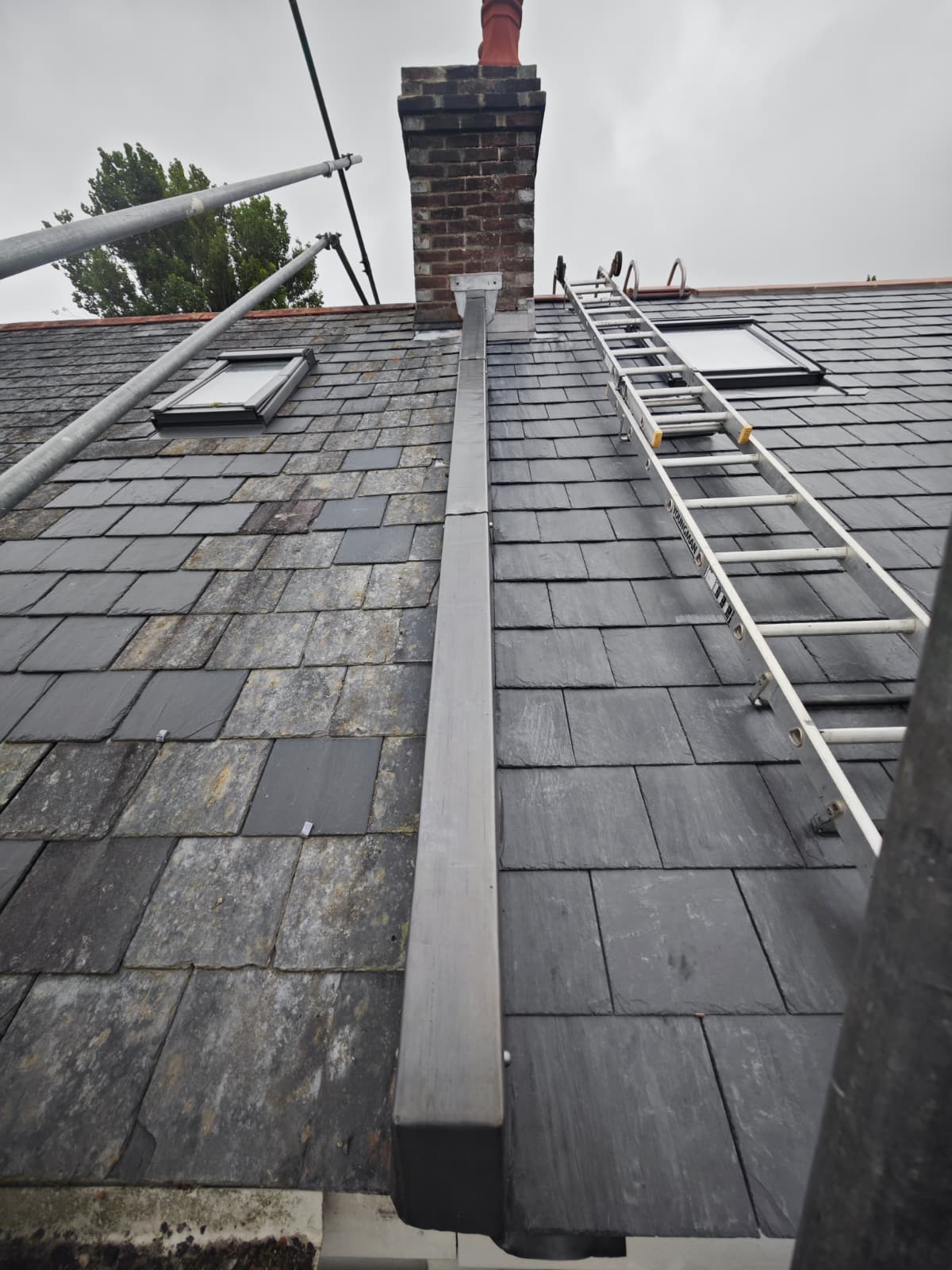 Slate roof with lead hip roll, Velux windows and chimney, L'Enclos Cottages