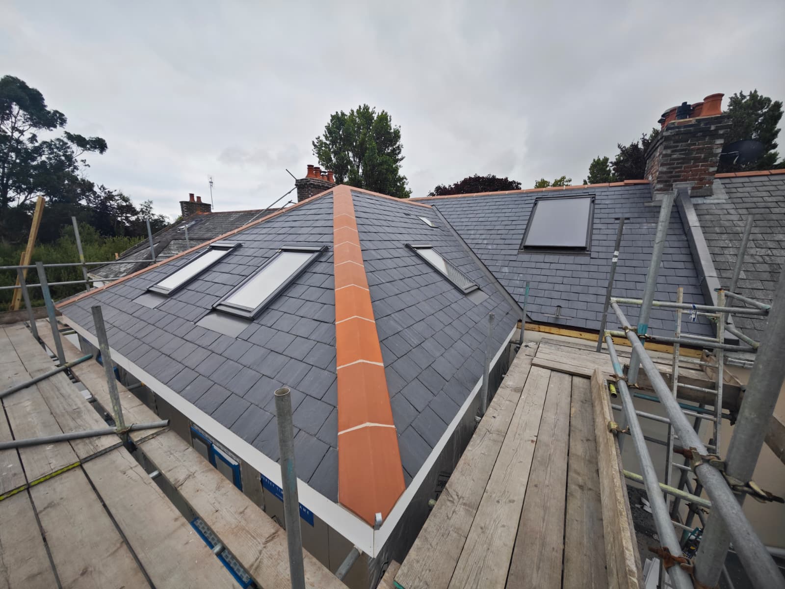 Hipped slate roof with clay ridge, Velux windows and solar panel, L'Enclos Cottages