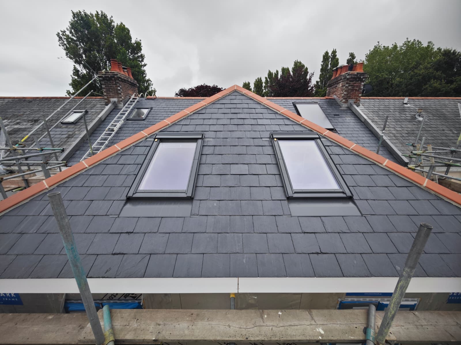 Slate gable with paired Velux windows and clay ridge tiles, L'Enclos Cottages