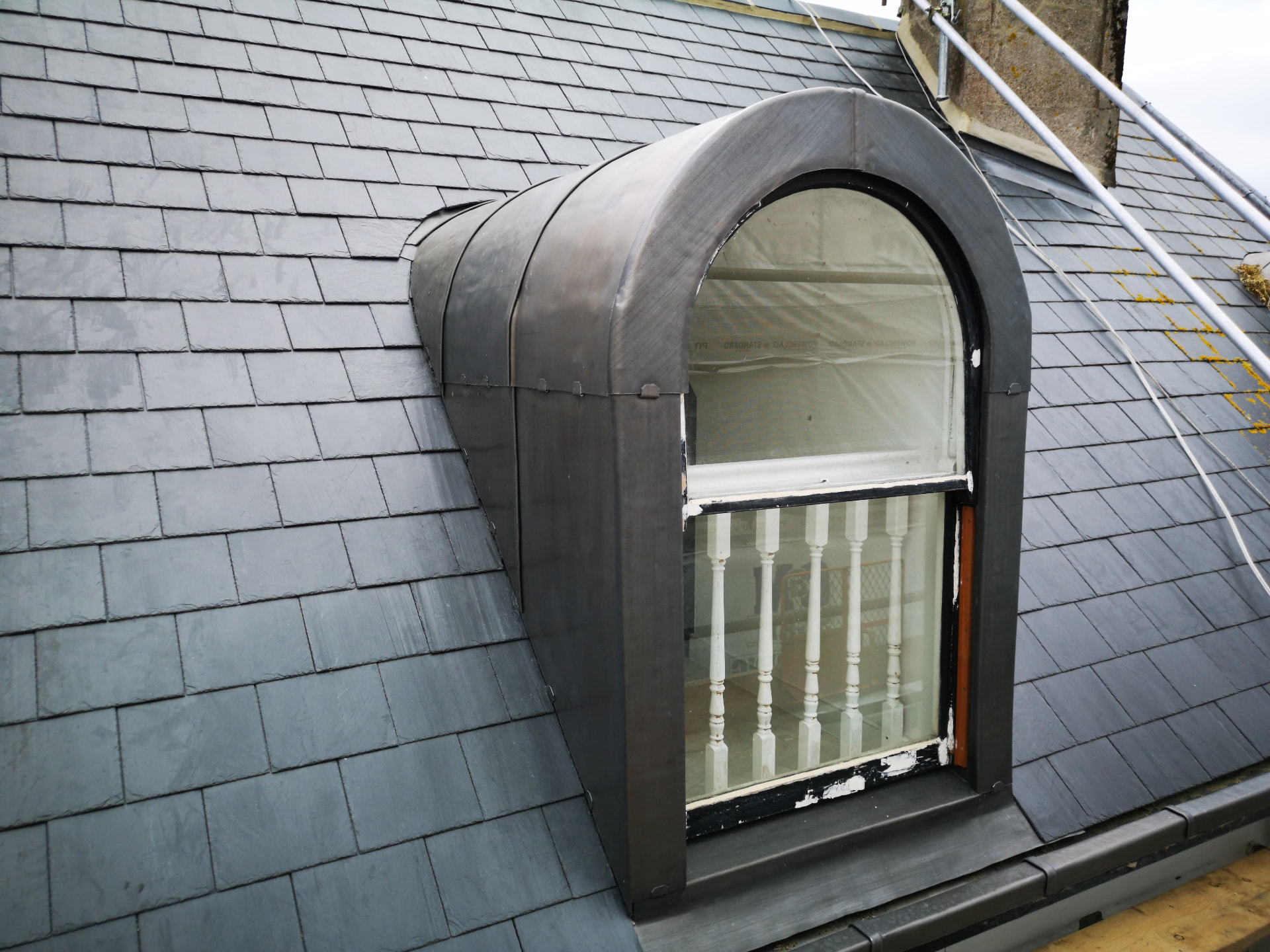 Curved lead-clad barrel dormer set into a slate roof, Broad Street