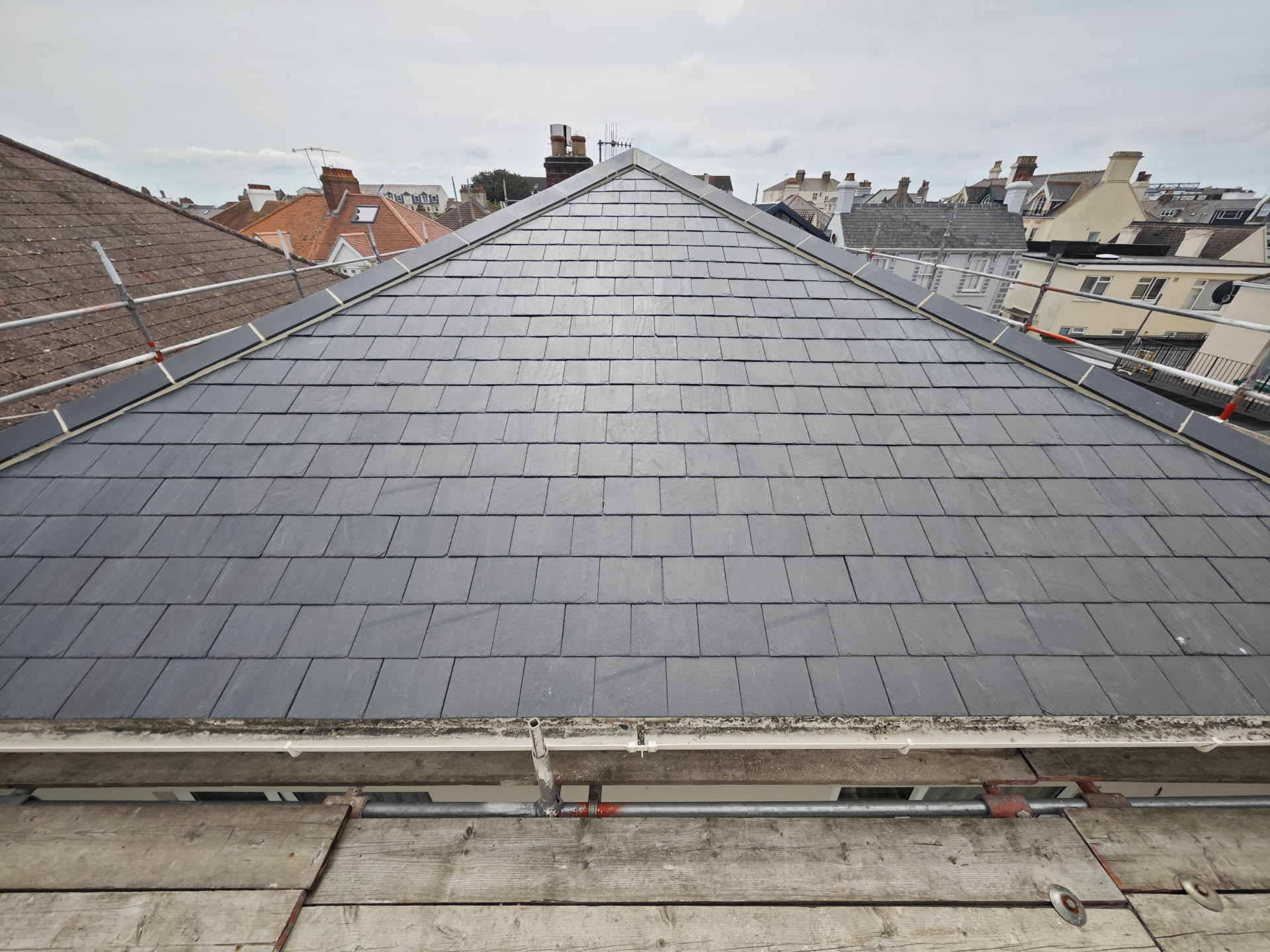 New slate gable roof with lead verge over rooftops, L'Abri