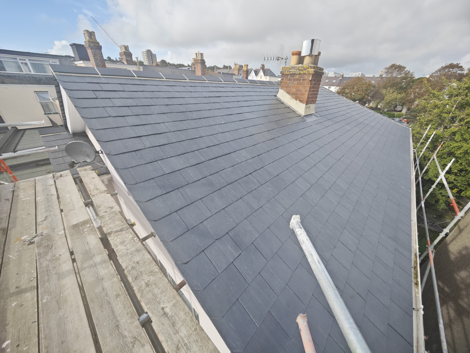 Wide slate roof slope with brick chimney and lead flashing, L'Abri