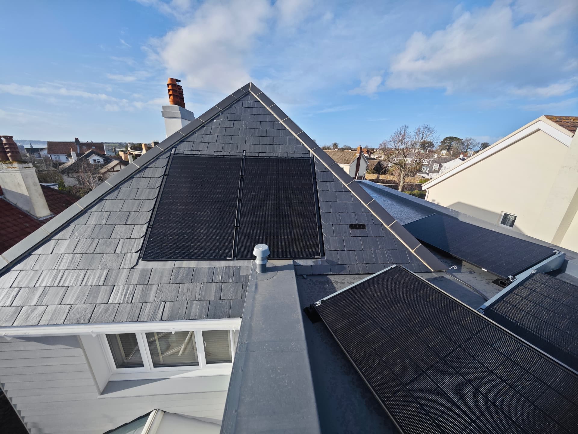 Spanish slate hipped roof with PV solar panels and warm flat roof, Le Clos