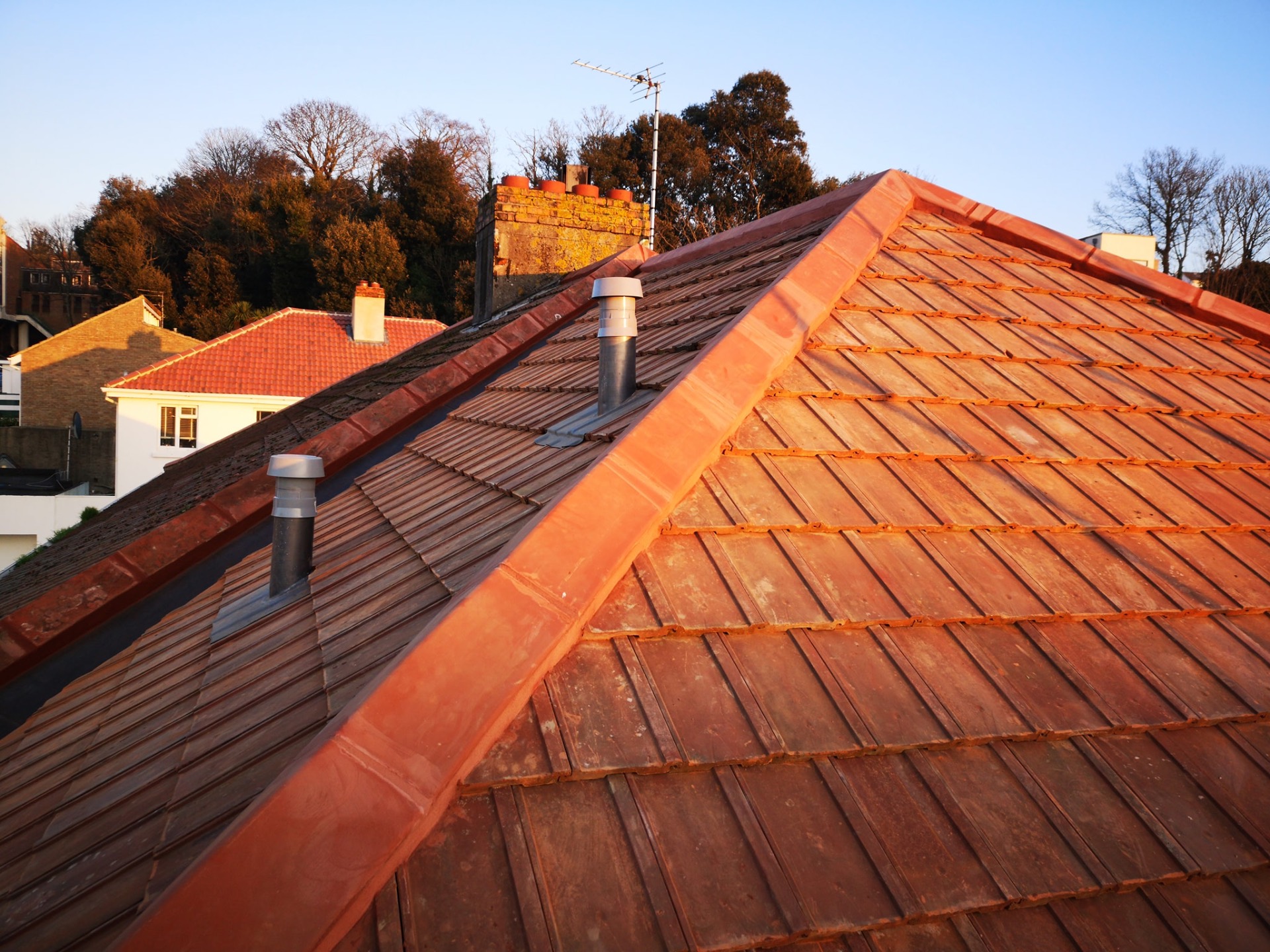Restored red clay tile roof at golden hour