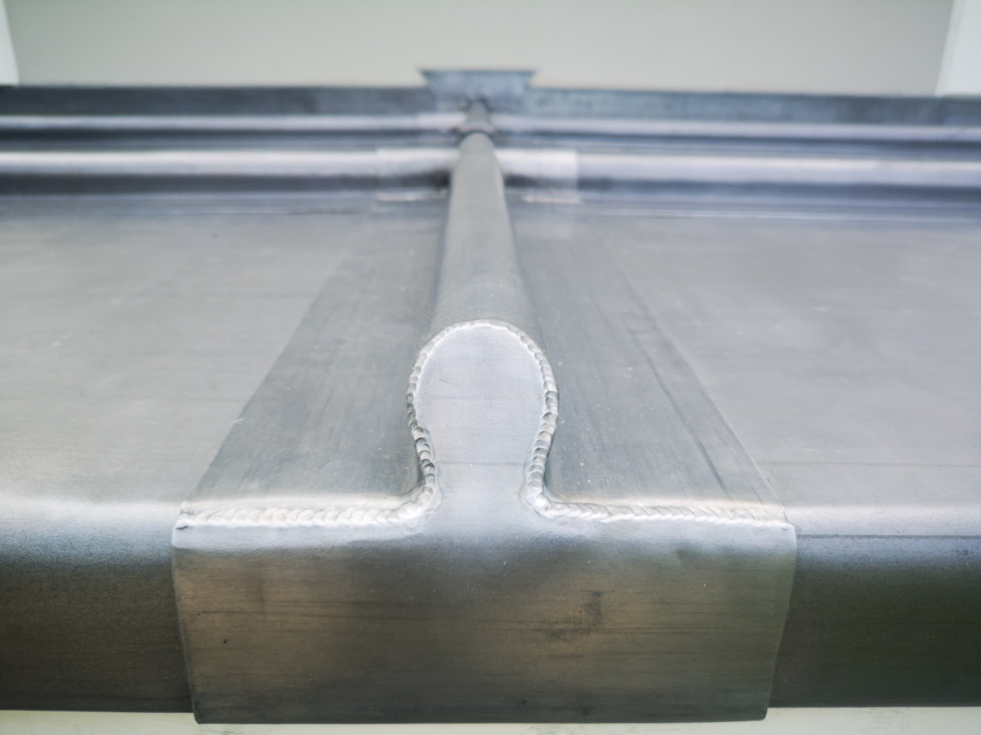 Close-up of a welded lead roll and drip detail on a porch roof, Crows Nest