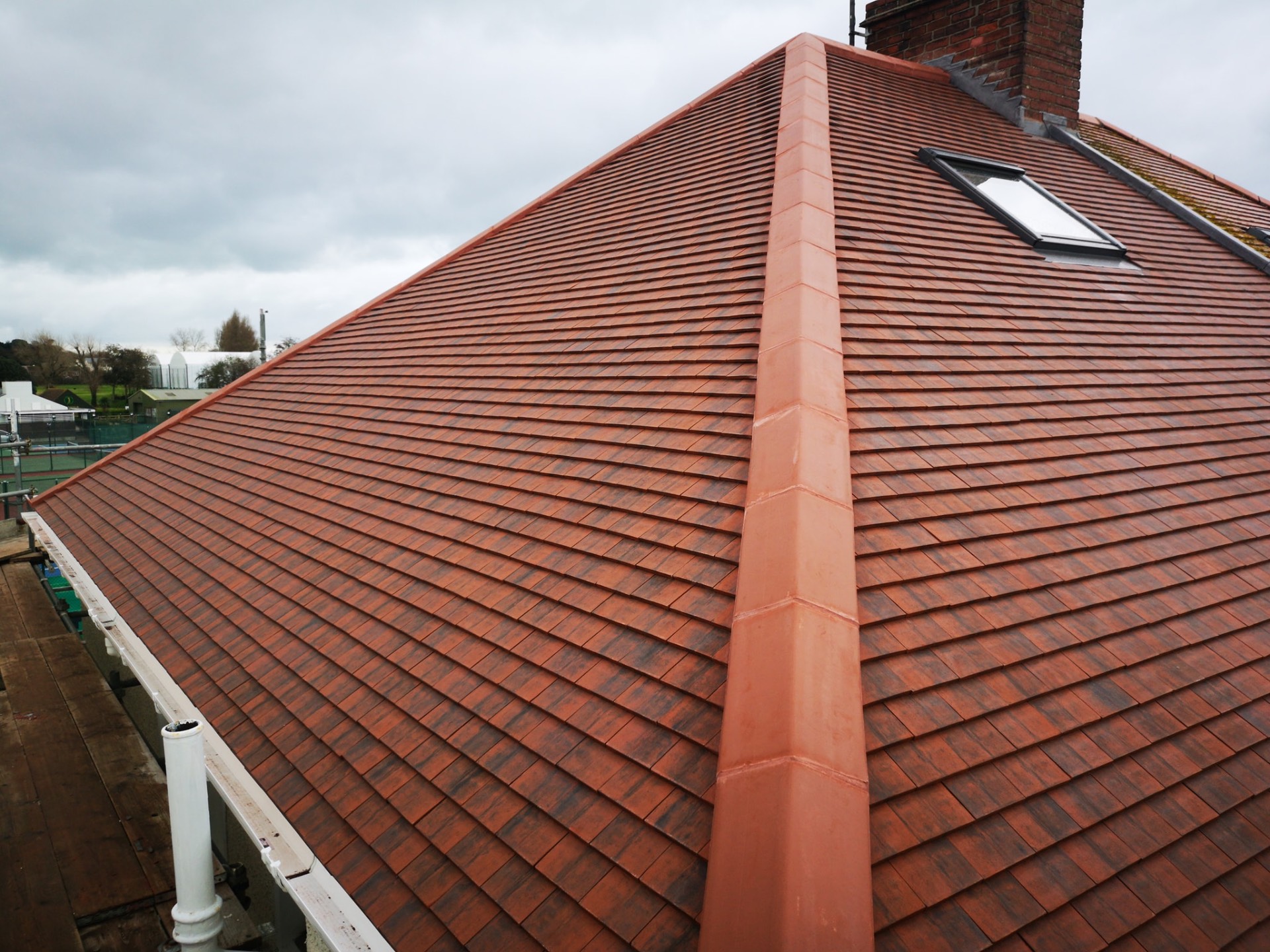 Plain red clay tile hipped roof with ridge tiles