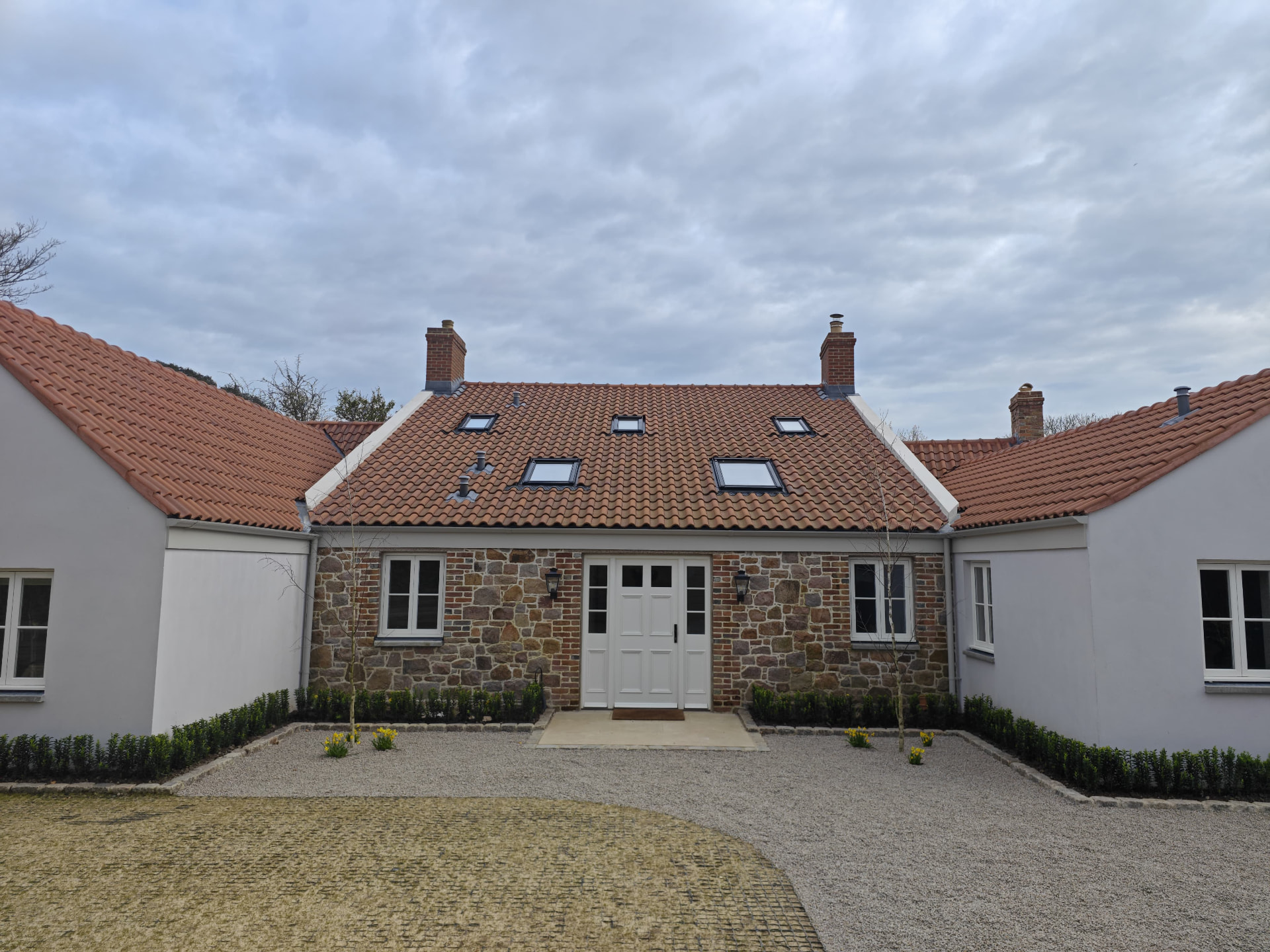 Courtyard elevation of a new build with clay pantile roofs and Velux windows, Rose Cottage