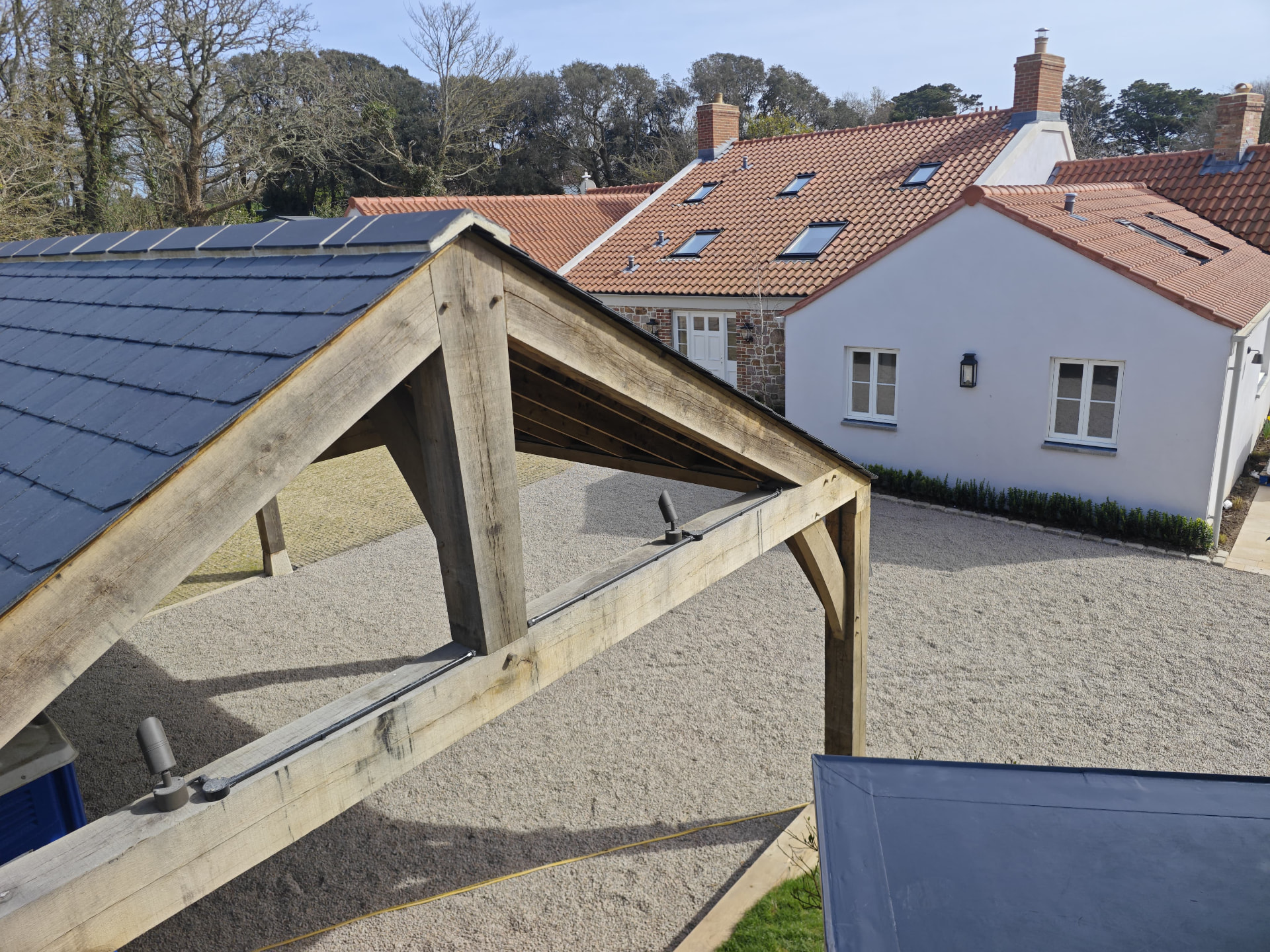 Oak framed car port with slate roof beside clay pantiled house, Rose Cottage