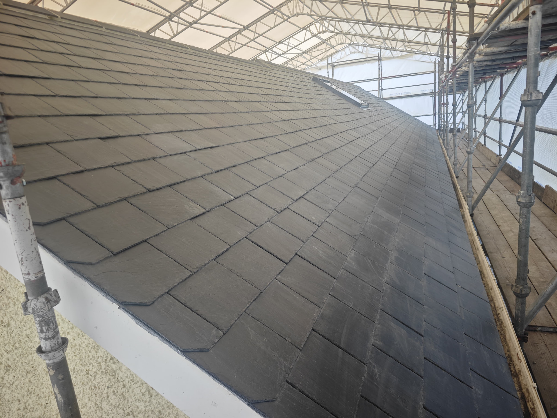 Neatly coursed natural slate slope with hip detail, Petite Menage
