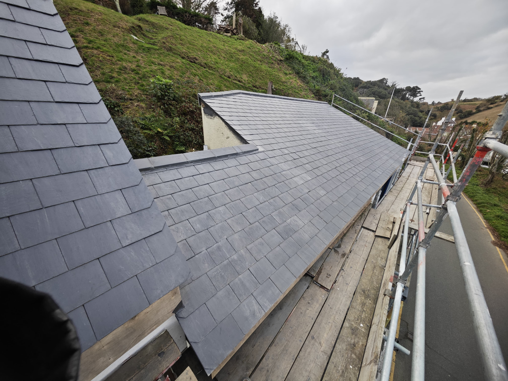 Freshly slated roof slopes with lead hips on a hillside house, Rivage de la Mer