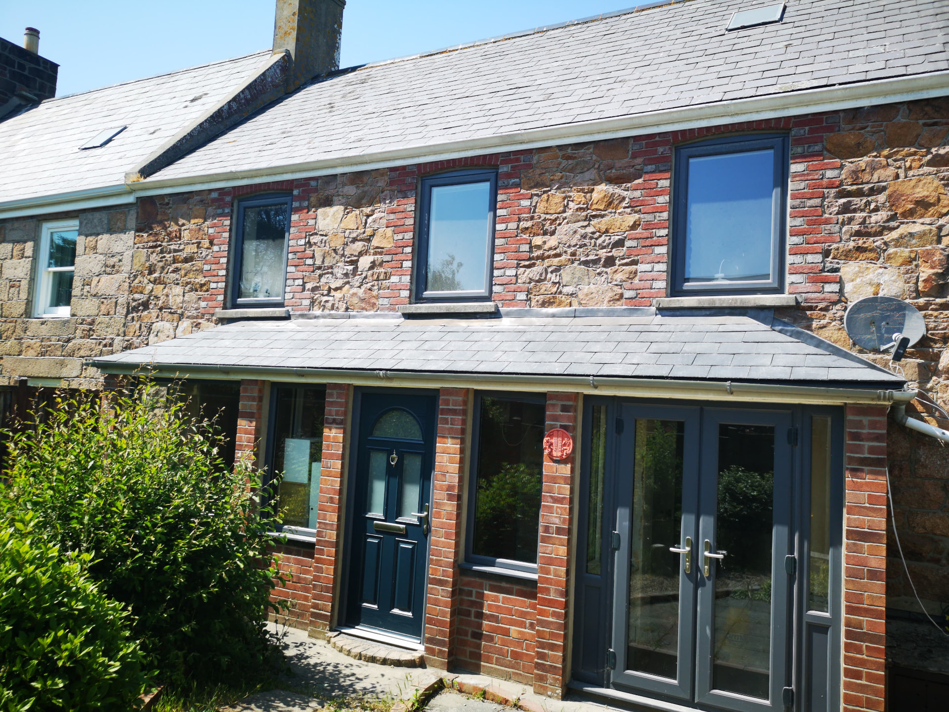Small hipped slate lean-to roof with lead flashing on a granite cottage, Woolston